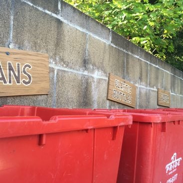 red recycling bins labeled for different materials