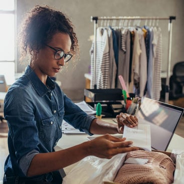 woman prepares to ship an order from a clothing boutique