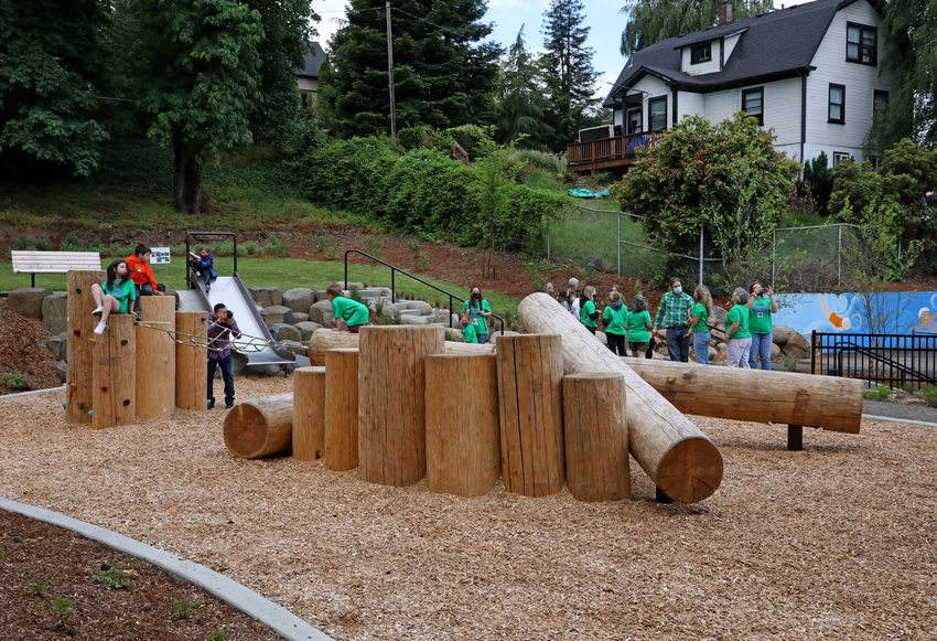 Image of children playing on logs in a natural play area