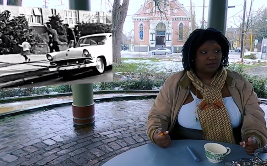 screenshot from film showing a youth sitting at a table outside with a tea cup on the table