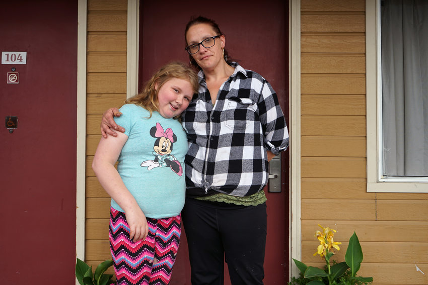 White woman and daughter standing in front of exterior door