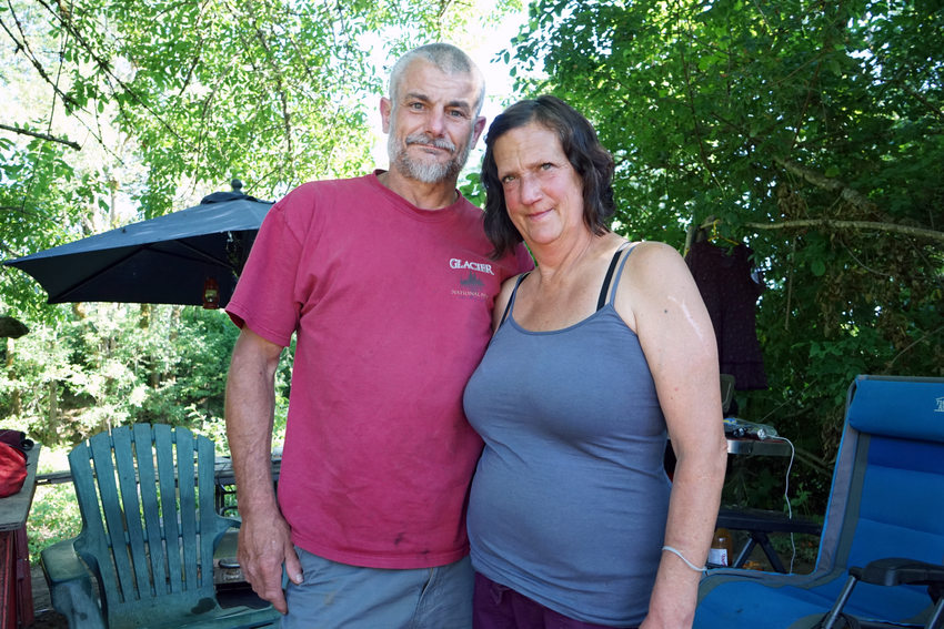 Man in red shirt with short grey hair and woman in blue tank top standing together