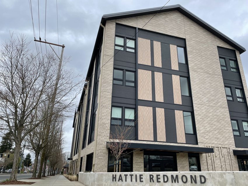 Four story apartment building with signage reading "Hattie Redmond"