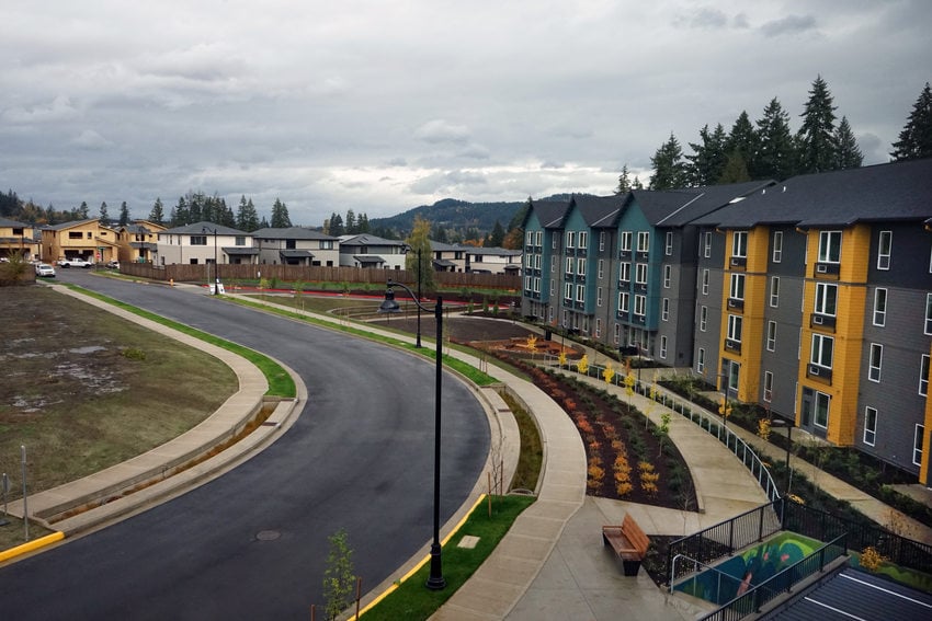 Suburban street with multicolored housing lining a curved road.