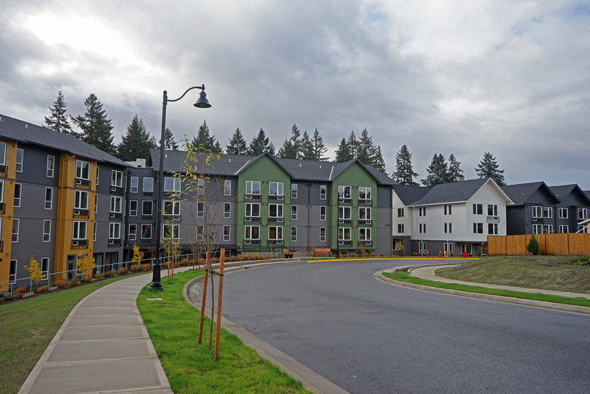 Suburban street with multicolored housing lining a curved road. 