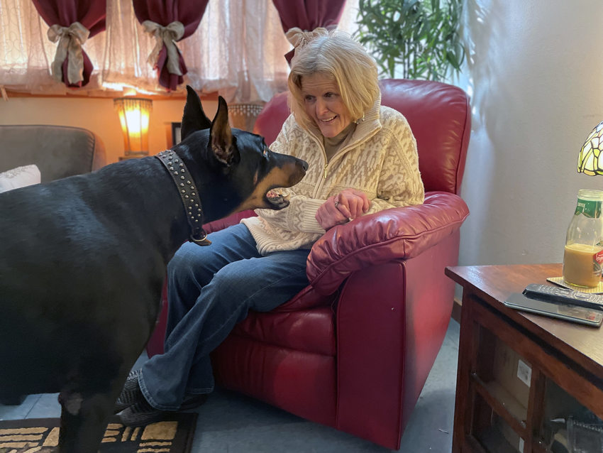 Senior woman and her dog in their living room. 