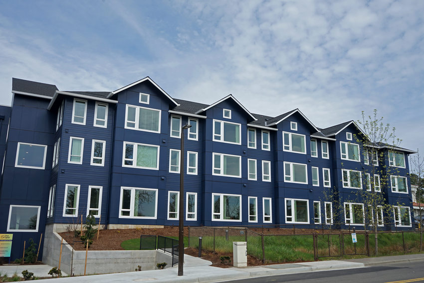 Three-story multifamily building with blue exterior and white trim.
