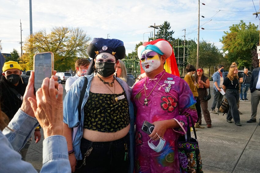 Two people in nun drag posing for a photo outside a celebration.