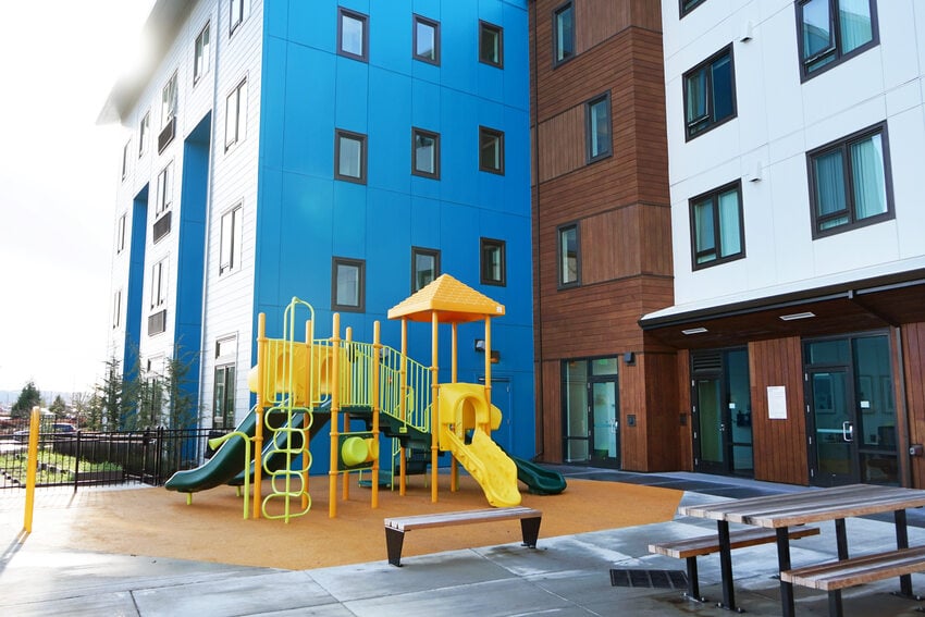 Apartment building courtyard with playground and picnic table. 