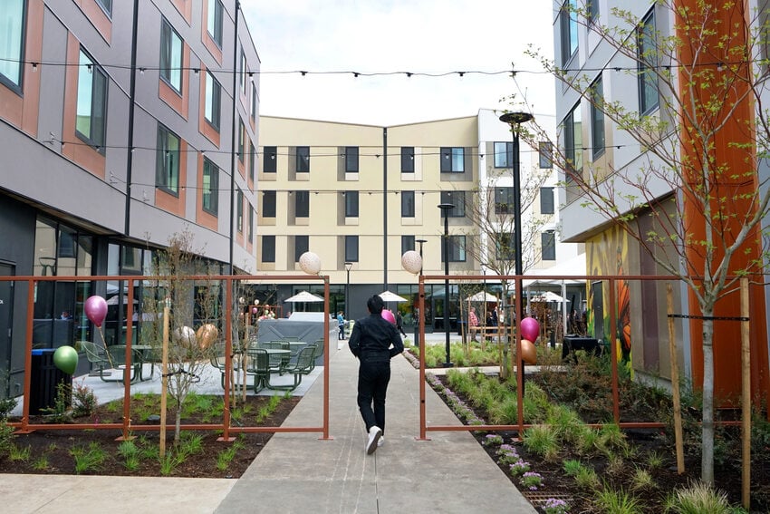 Entrance to apartment complex courtyard with multiple buildings.