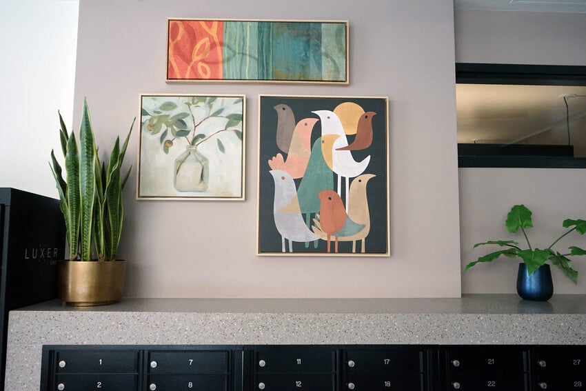 Mail box area with framed art and plants.