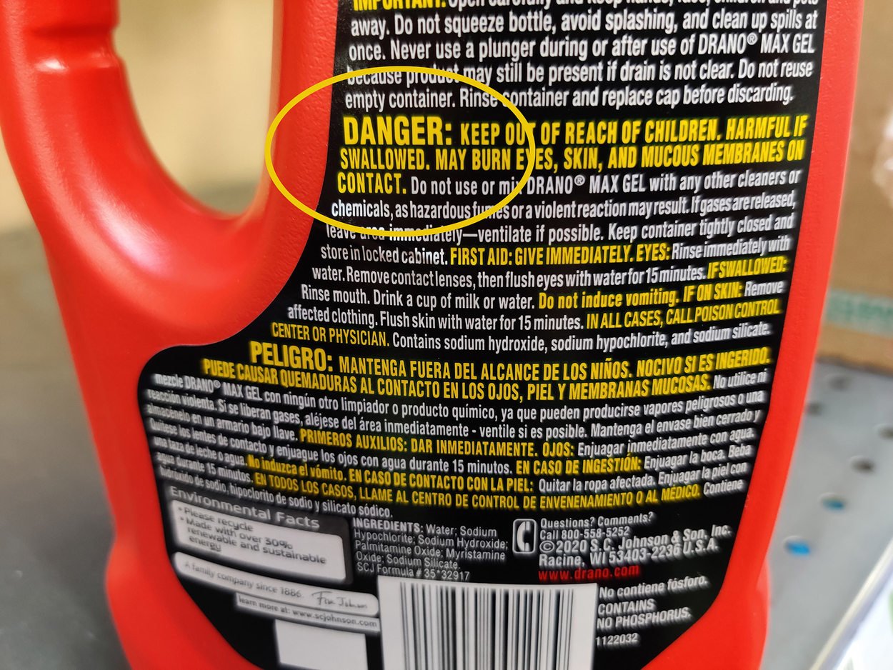 The bottom half of a red cleaner bottle, the word DANGER displays in bright yellow text against a black background