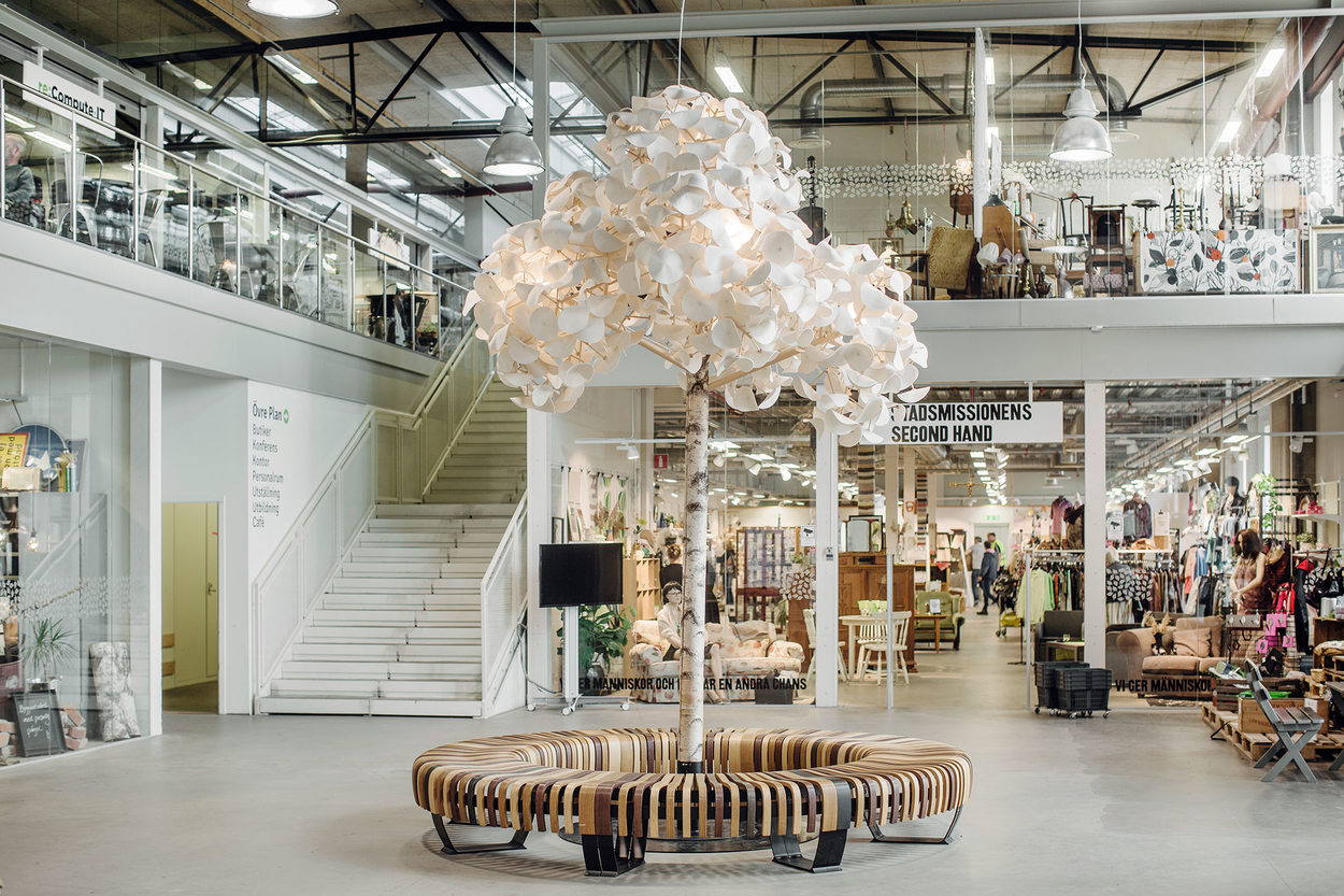 A tree made from recycled materials sits in the center of a reuse mall 