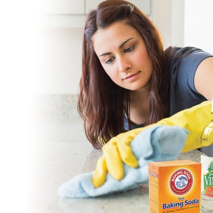 photo of woman cleaning with baking soda and vinegar