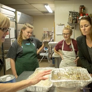 volunteers at Clackamas Service Center have a discussion around a table covered with food