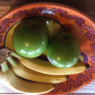 green apples and bananas in a bowl