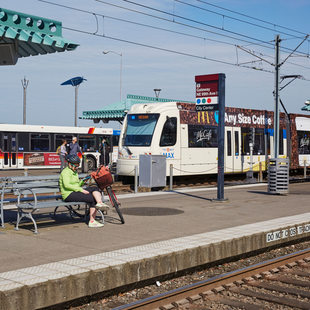 The Gateway MAX station with people waiting for light rail and boarding a bus.