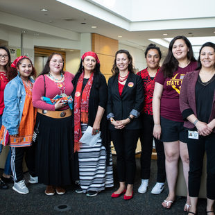 A group of Native American women stand side by side