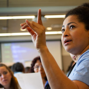 Woman raising her hand and speaking to a group