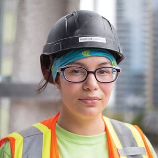 Photo of a woman wearing a hard hat and vest on a construction site