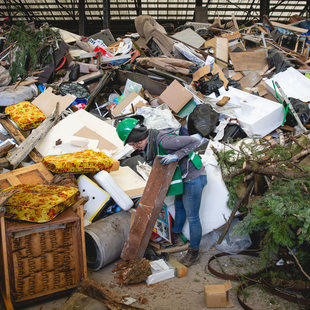 artist picks through giant pile of trash.