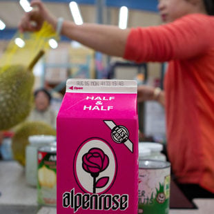 a carton of milk moves down the check out conveyor belt