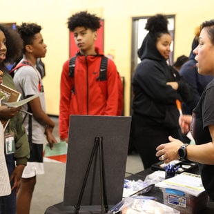 woman talking to students at SEI trades fair