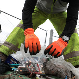 RID Patrol member picks up bags of garbage