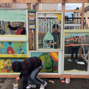 little boys working on an art installation in a backyard