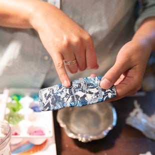 close-up of artist's hands holding plastic pieces melted together