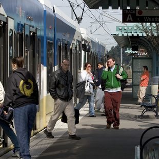 riders entering and exiting a MAX light rail train