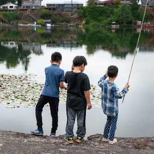 Three kids fishing from the shoreline at Blue Lake Park