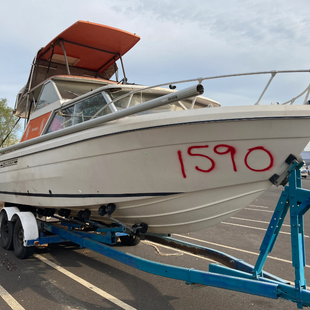 White boat on a blue trailer, the boat is marked with the number 1590 in red spray paint