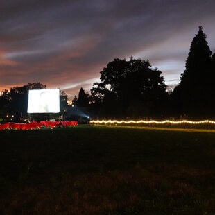 A wide view of Block 14 with the Serenading the Departed projection screen, tables and audience in the background.