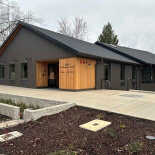 Grey and unfinished wood building with pitched roof. 