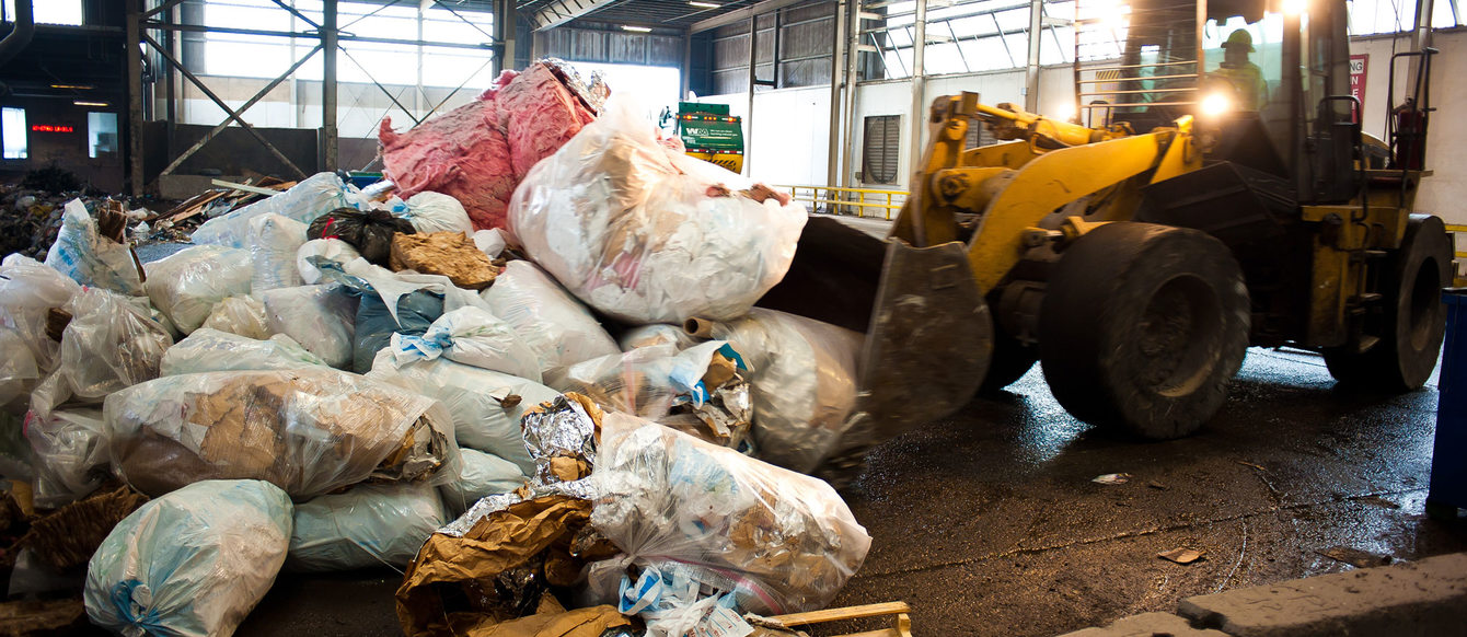 photo of backhoe pushing garbage at Metro South