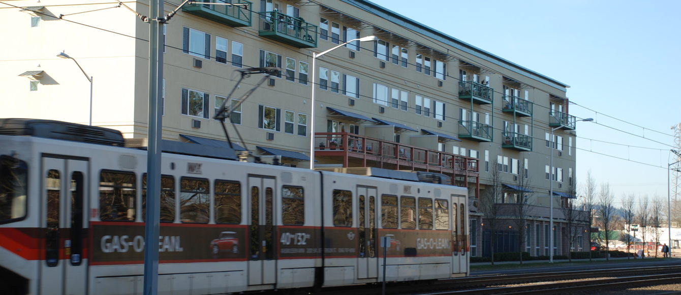 a photo of a large building with a MAX train in the foreground