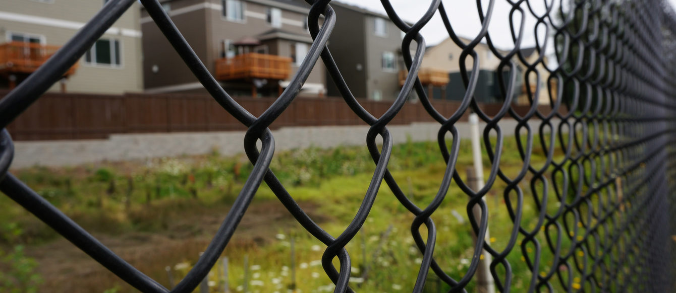 Fence with new houses behind it