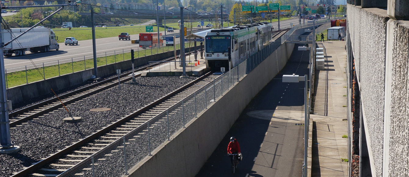 Wide shot of MAX, bike, freeway at Clackamas Town Center