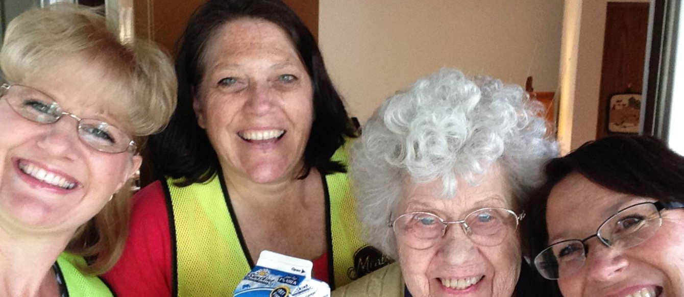 food recipient poses with volunteers