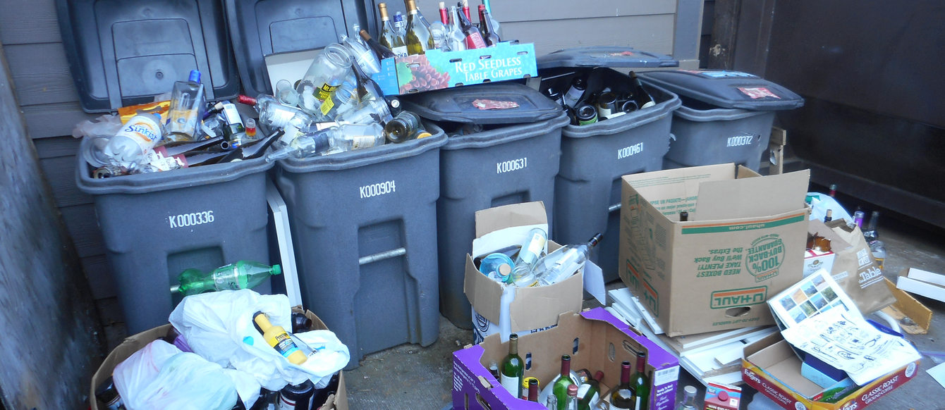 grey recycling bins overflowing with materials to be recycled