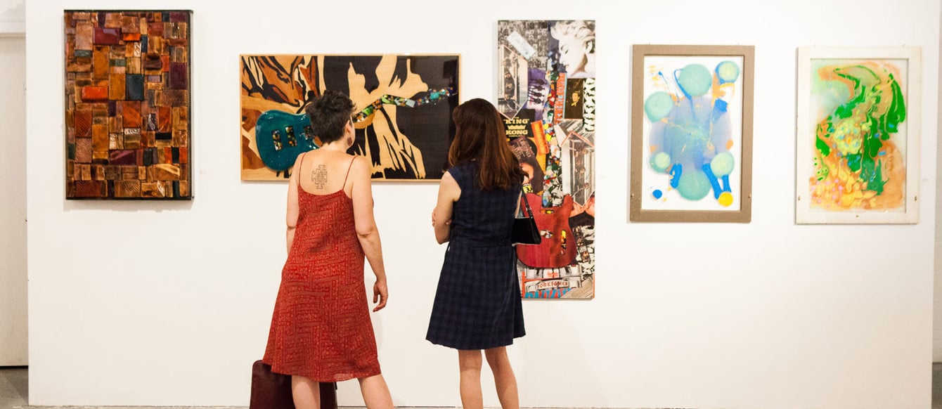 two women viewing artwork displayed at GLEAN exhibit