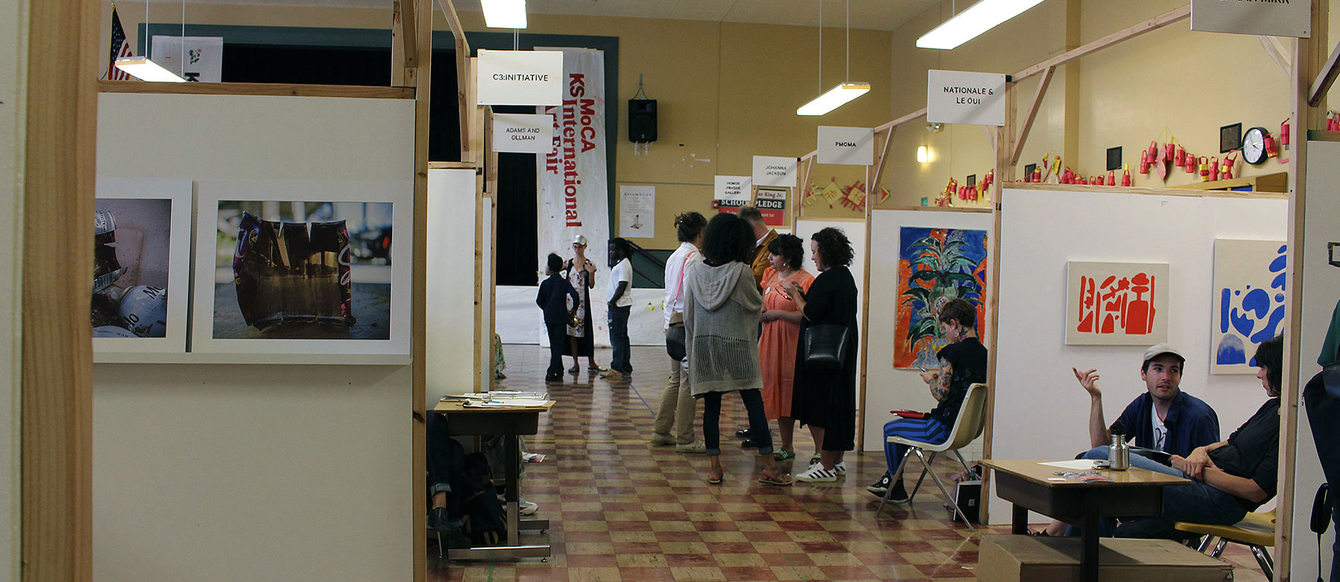 an art fair in a school cafeteria with individual artist booths set up