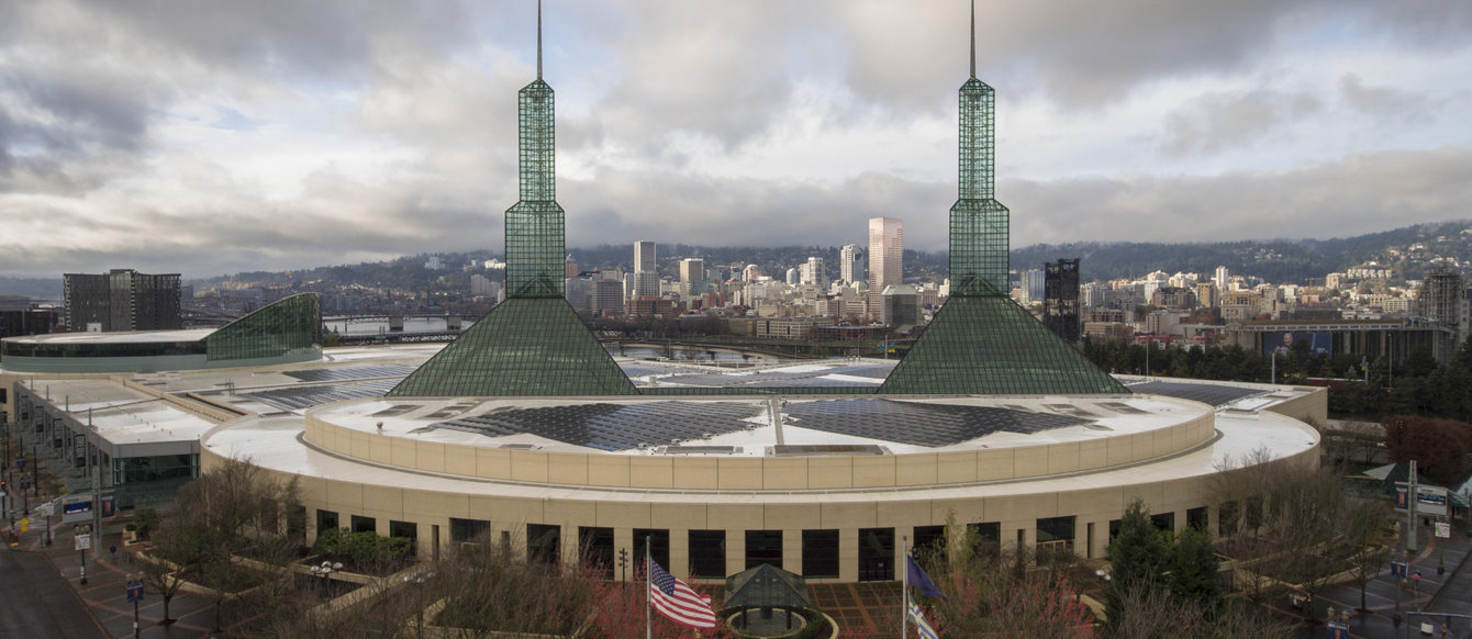 Oregon Convention Center in the daytime with the Portland skyline in the background