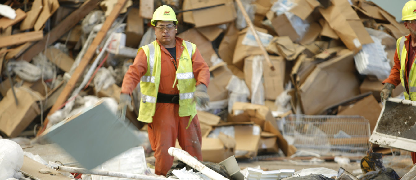 men sort through piles of trash 