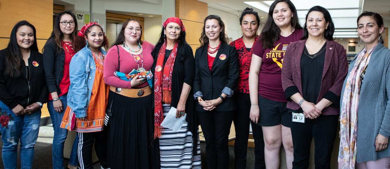 A group of Native American women stand side by side