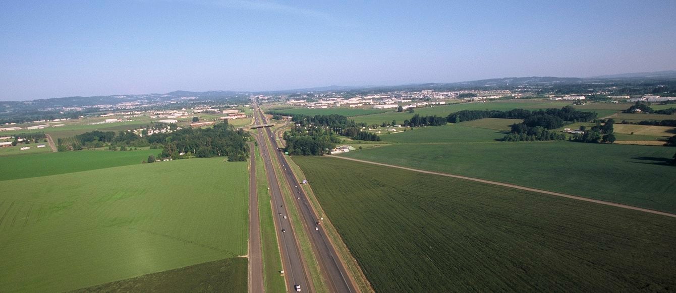 Photo of a highway with farm fields on either side