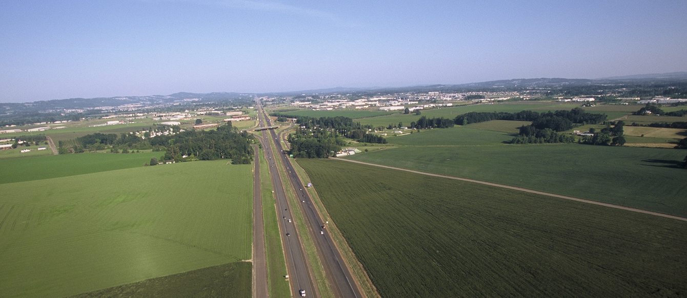 Photo of a highway with farm fields on either side