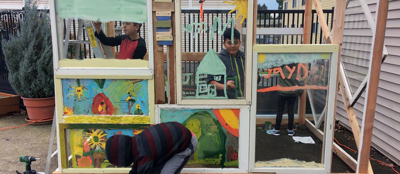 little boys working on an art installation in a backyard