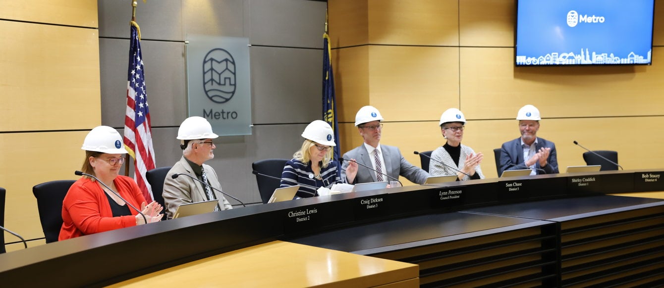 Metro Councilors sit at the chairs in Council Chambers wearing hard hats